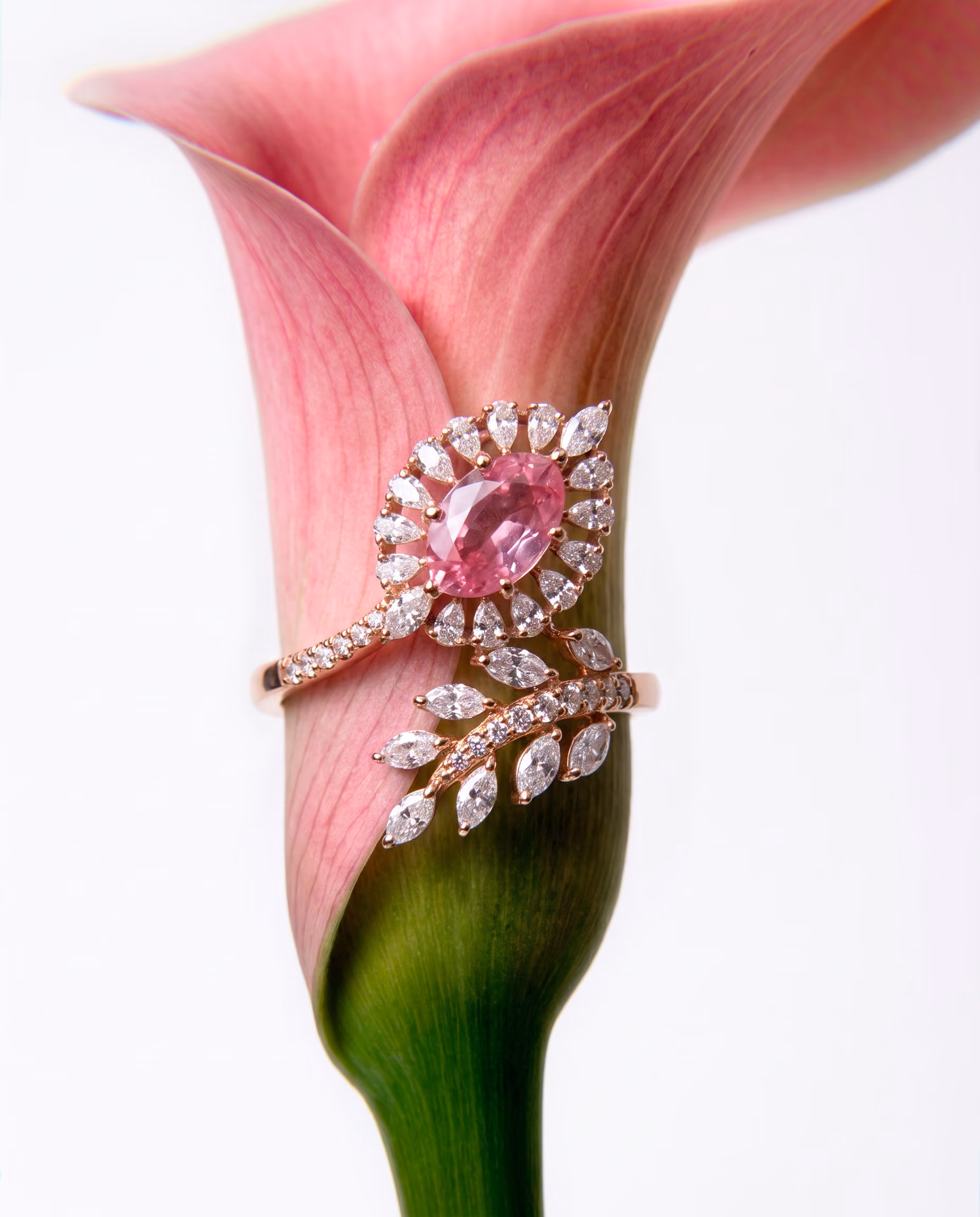 Rose gold ring with pink sapphire and diamond accents displayed on a pink calla lily flower.