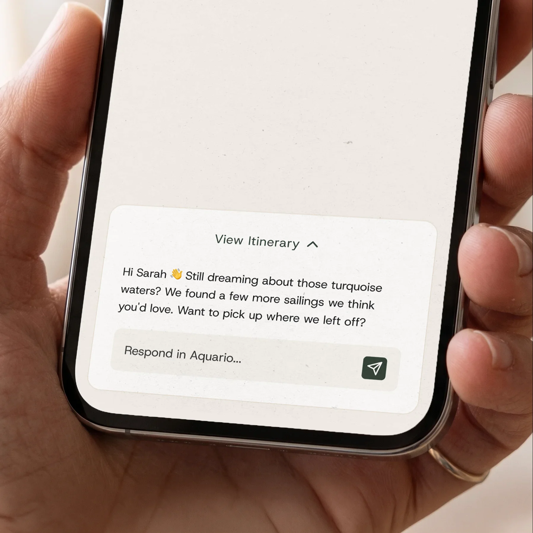Phone screen shows Aquario's chat interface inviting Sarah to view more turquoise water sailings and continue planning.