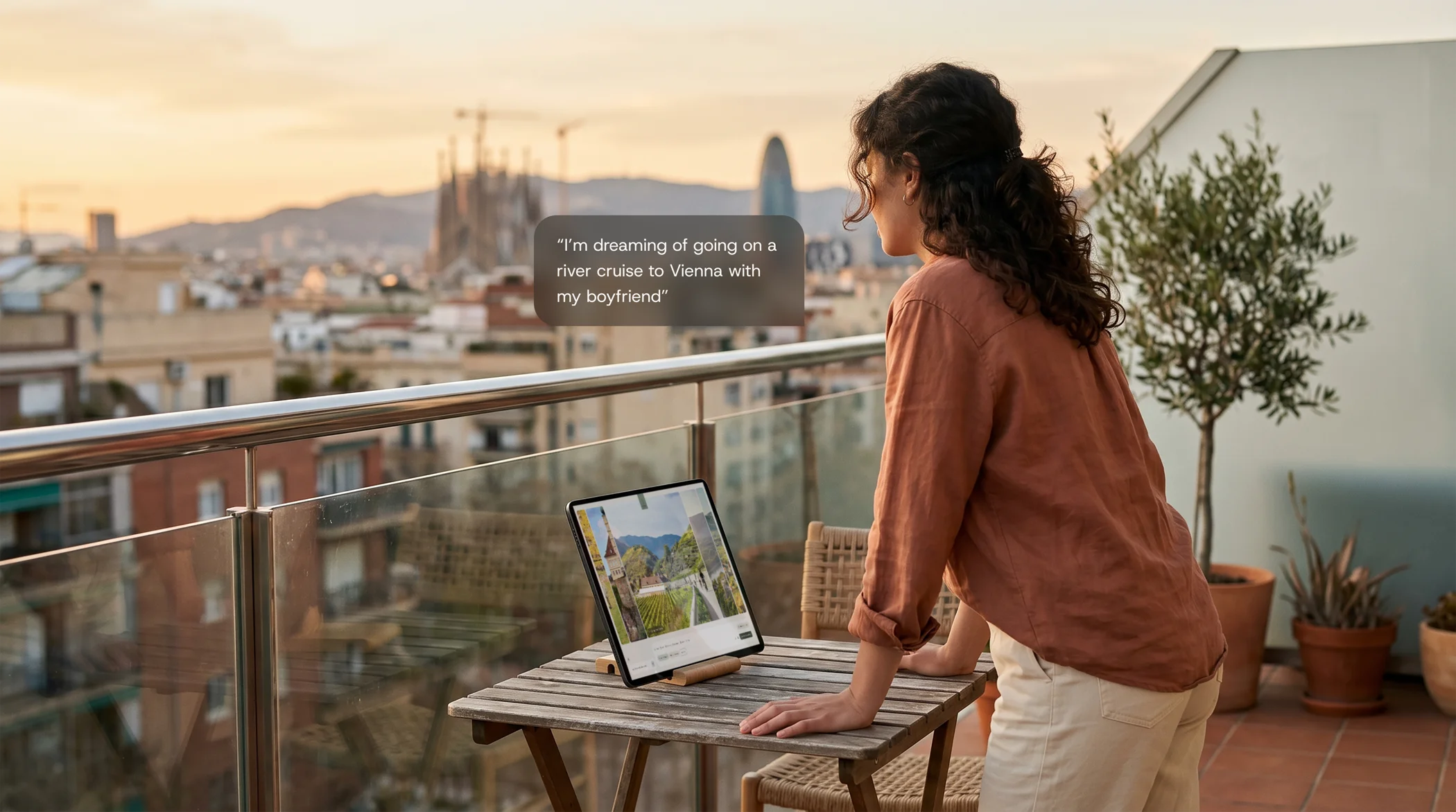 Woman on balcony looking at tablet with the Aquario interface showing Vienna travel images during sunset.