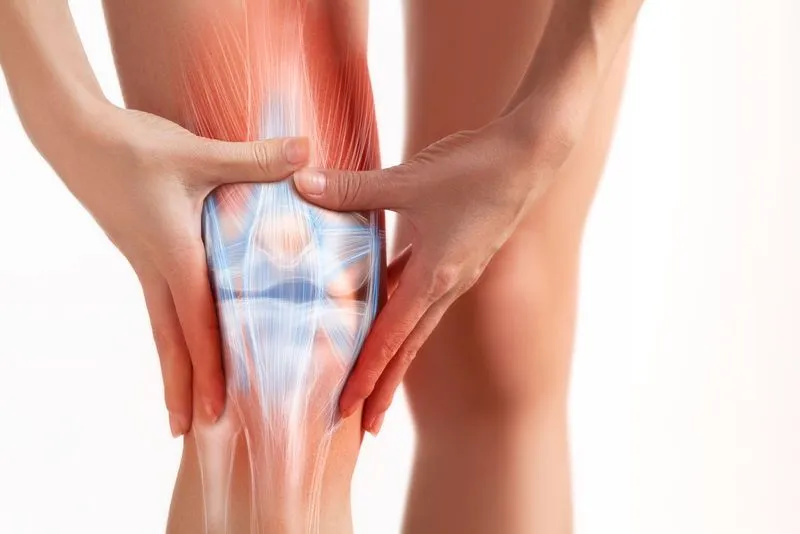 A woman holding her knee with both hands.
