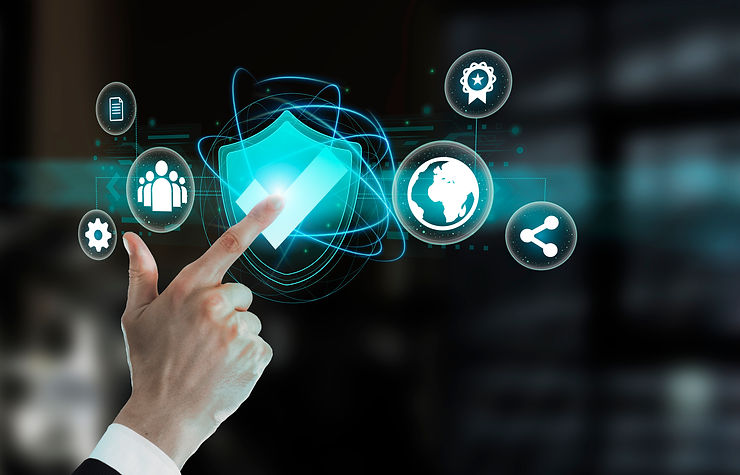 Hand touches glowing digital shield icon with checkmark, surrounded by various technology icons on a dark background.
