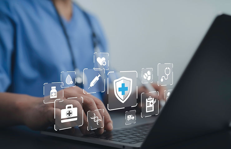 A person in blue scrubs types on a laptop, with digital healthcare icons floating above, indicating medical technology use.