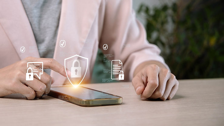 Hands interacting with a smartphone, holographic security icons floating above. Background blurred, setting is a neutral workspace.