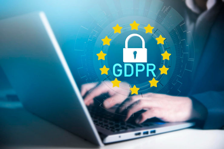 Hands typing on a laptop with a blue overlay. GDPR text with a lock icon and yellow stars is prominent. Tech and data security theme.