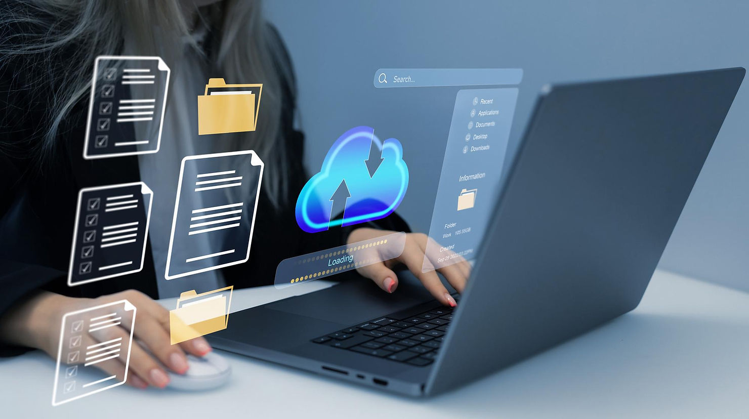 Person using a laptop with cloud upload/download icons, folders, and file panels floating on screen in a modern office setting