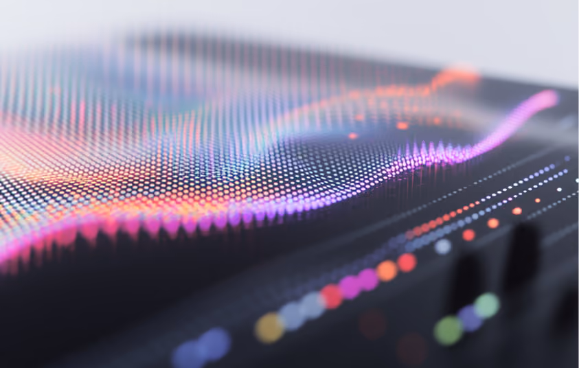Abstract digital waves composed of colorful glowing dots forming a flowing, grid-like surface.