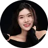 Smiling young woman with long dark hair wearing a black off-shoulder top against white background.