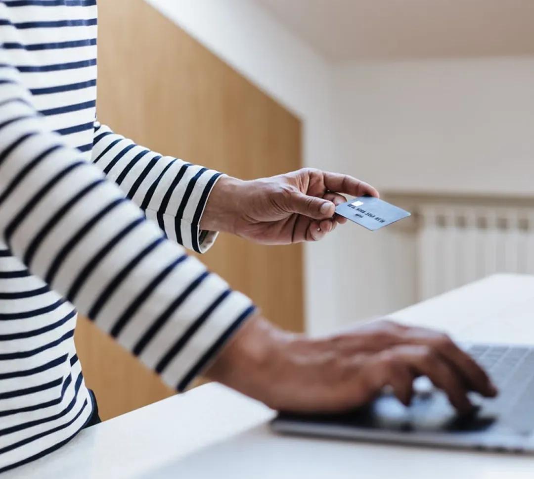 Person entering card details on a laptop.