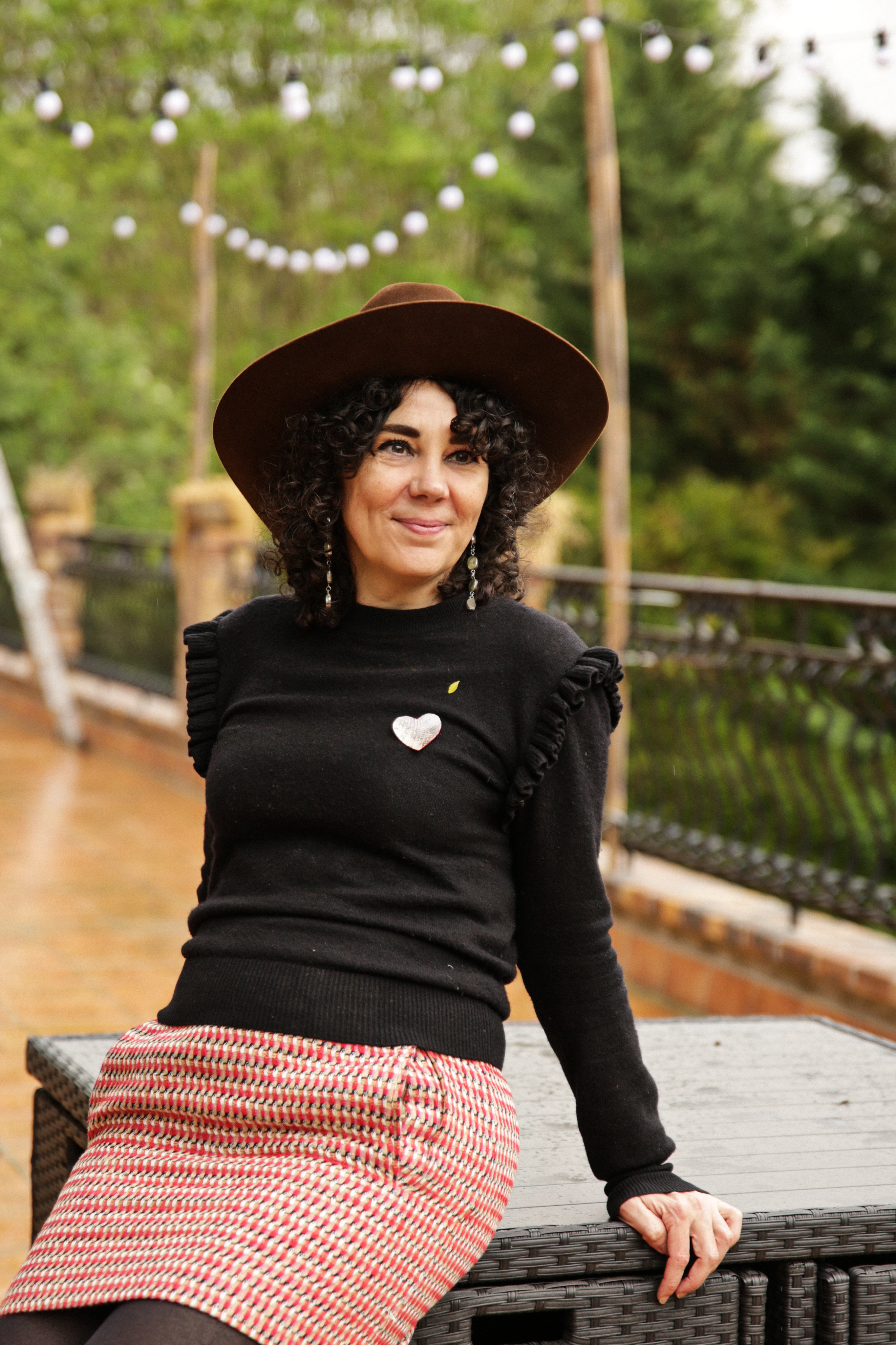 Photo de Amélie Faligot avec un chapeau de cowboy dans un jardin