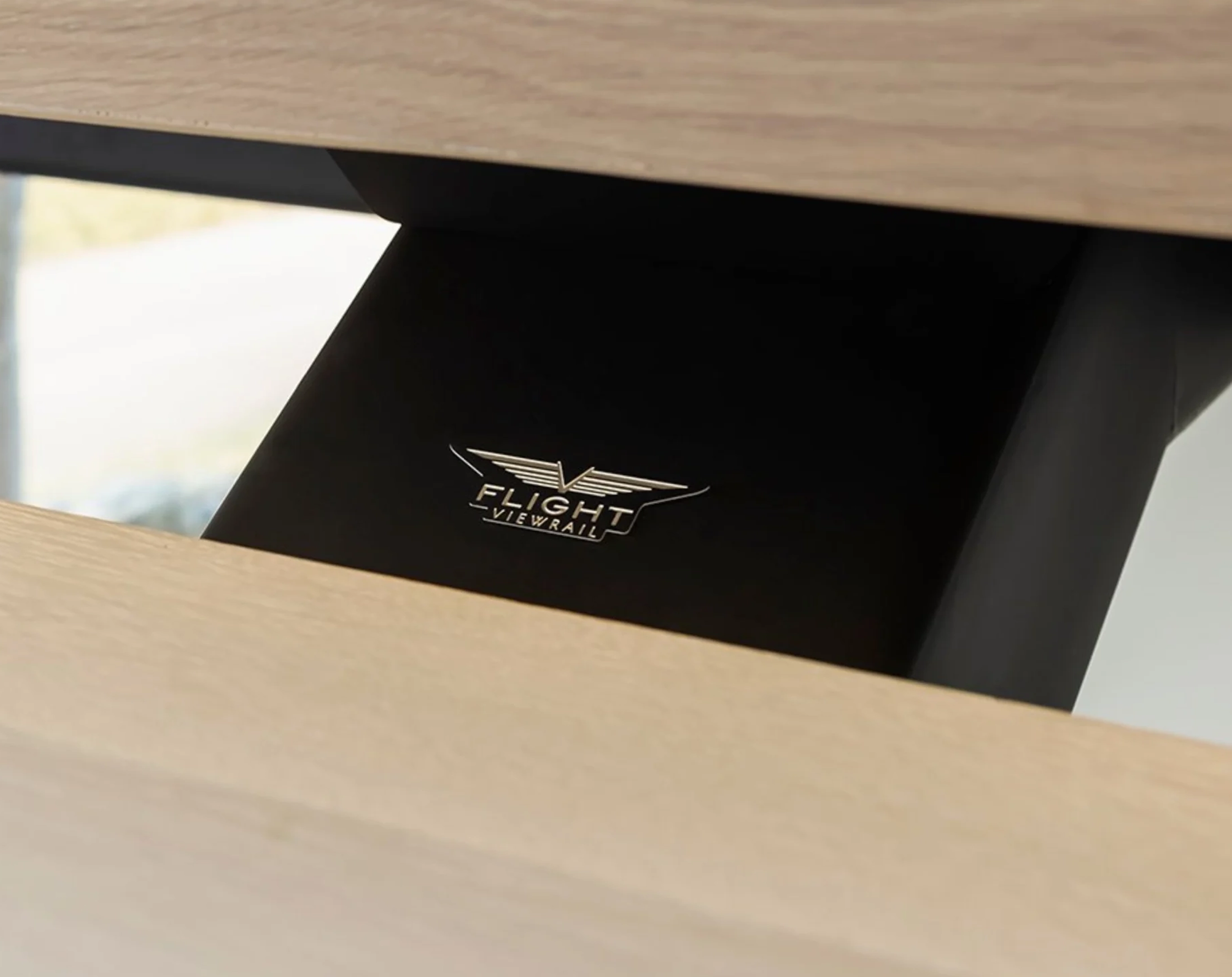 Close-up of black support beam with Flight Viewrail logo between wooden stairs.