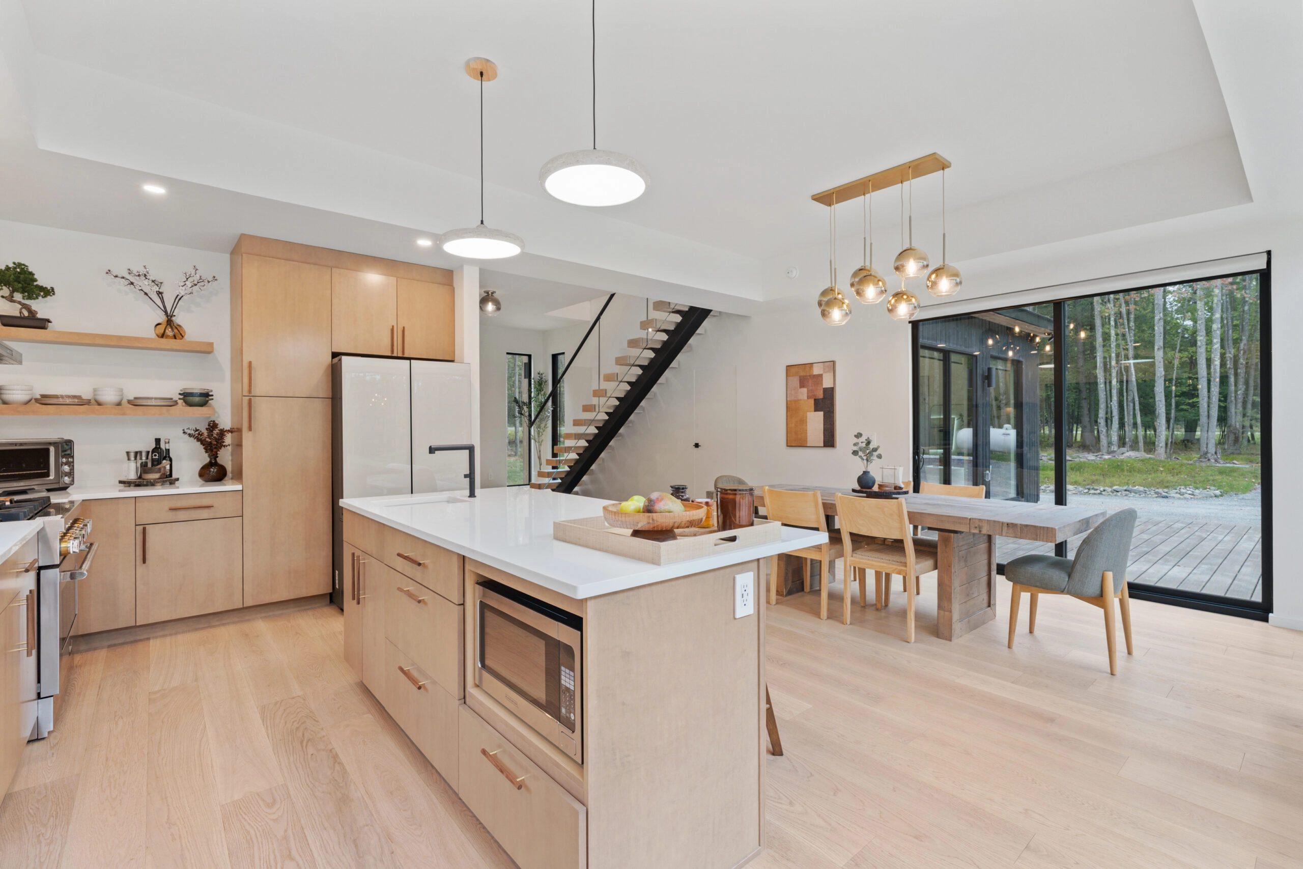 An open kitchen and dining room, FLIGHT Mono stair rising behind the island