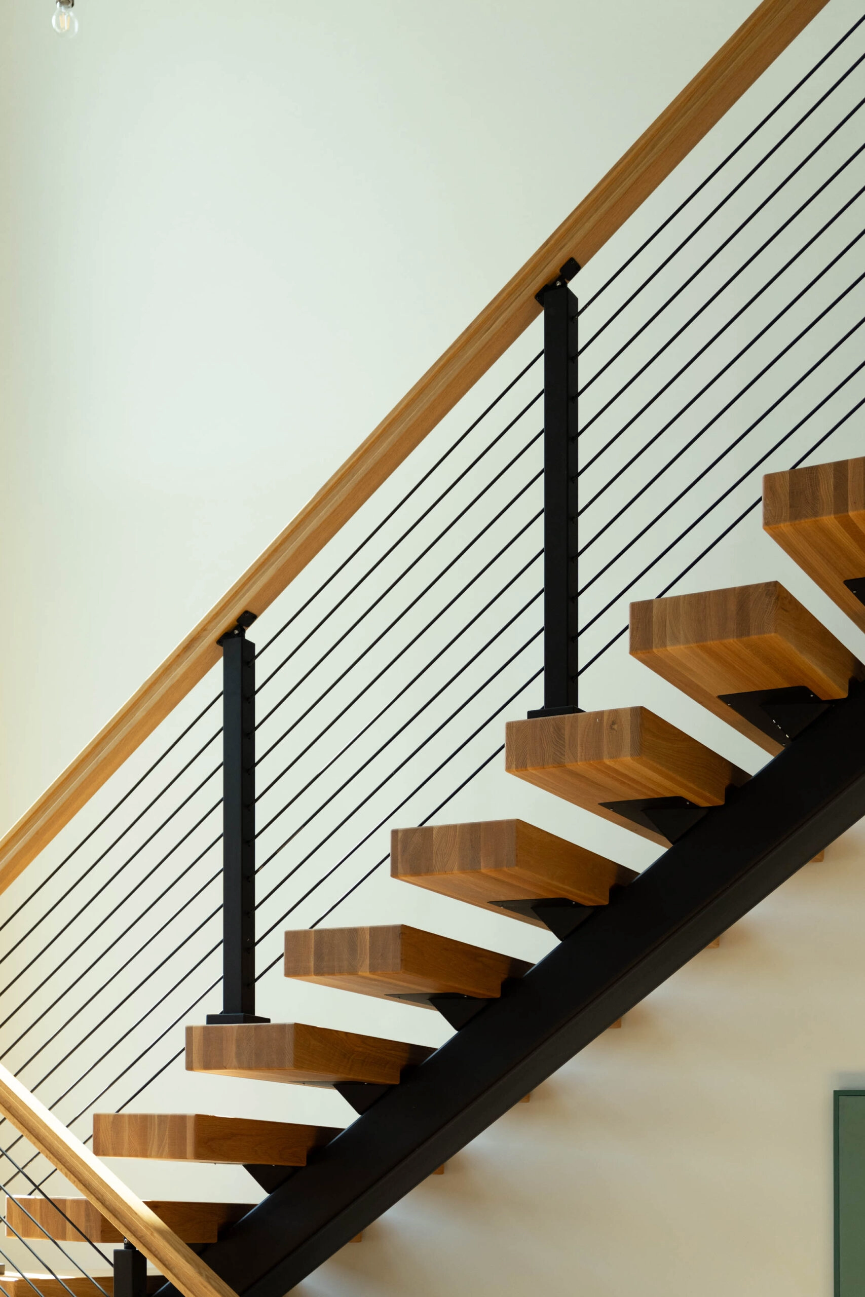 A FLIGHT Mono stair on a black stringer, wood treads and black Signature Rod infill