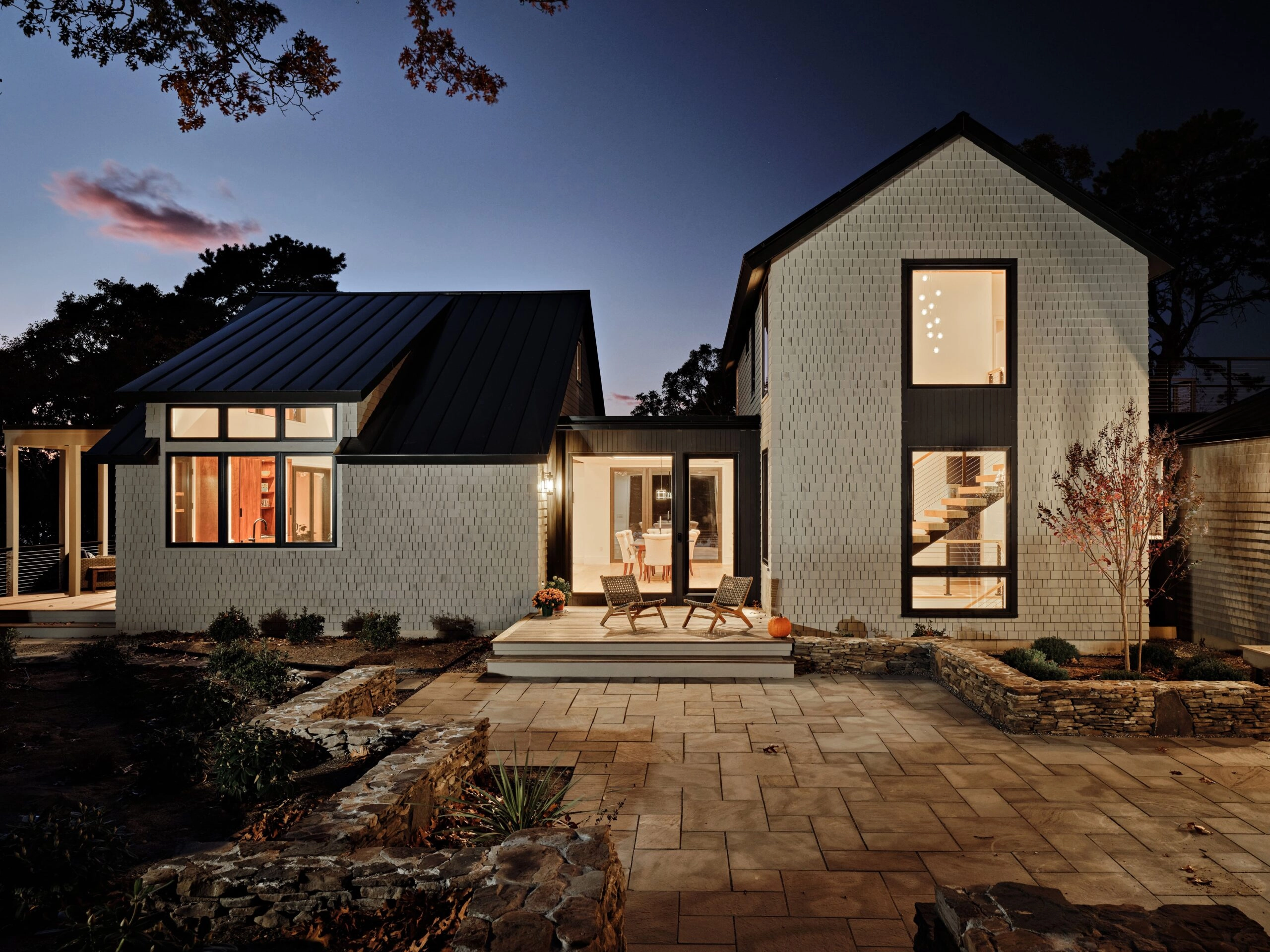 A home at dusk with a FLIGHT Mono stair lit inside the tall entry window