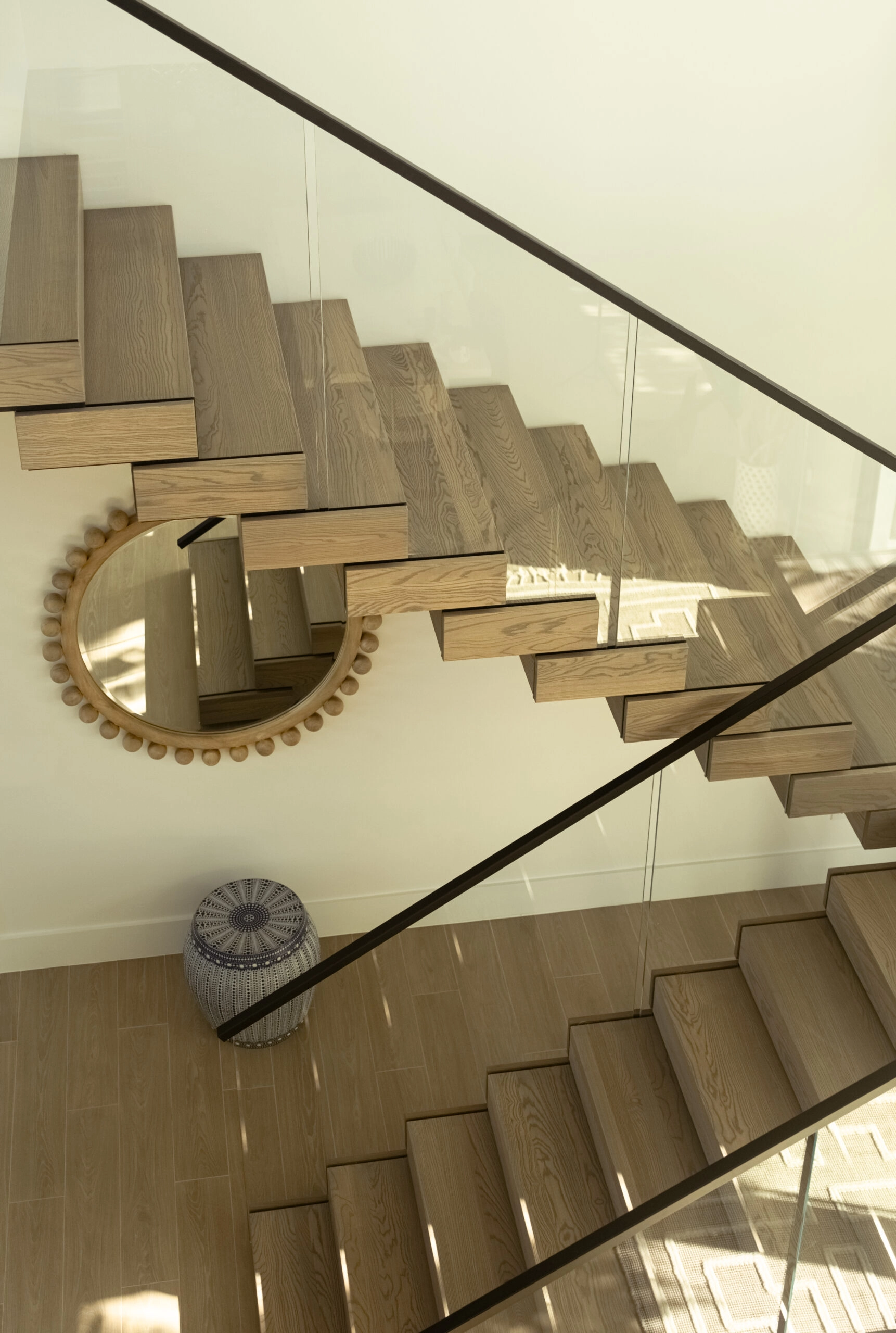 A beaded mirror below FLIGHT Stack treads, seen from the landing above