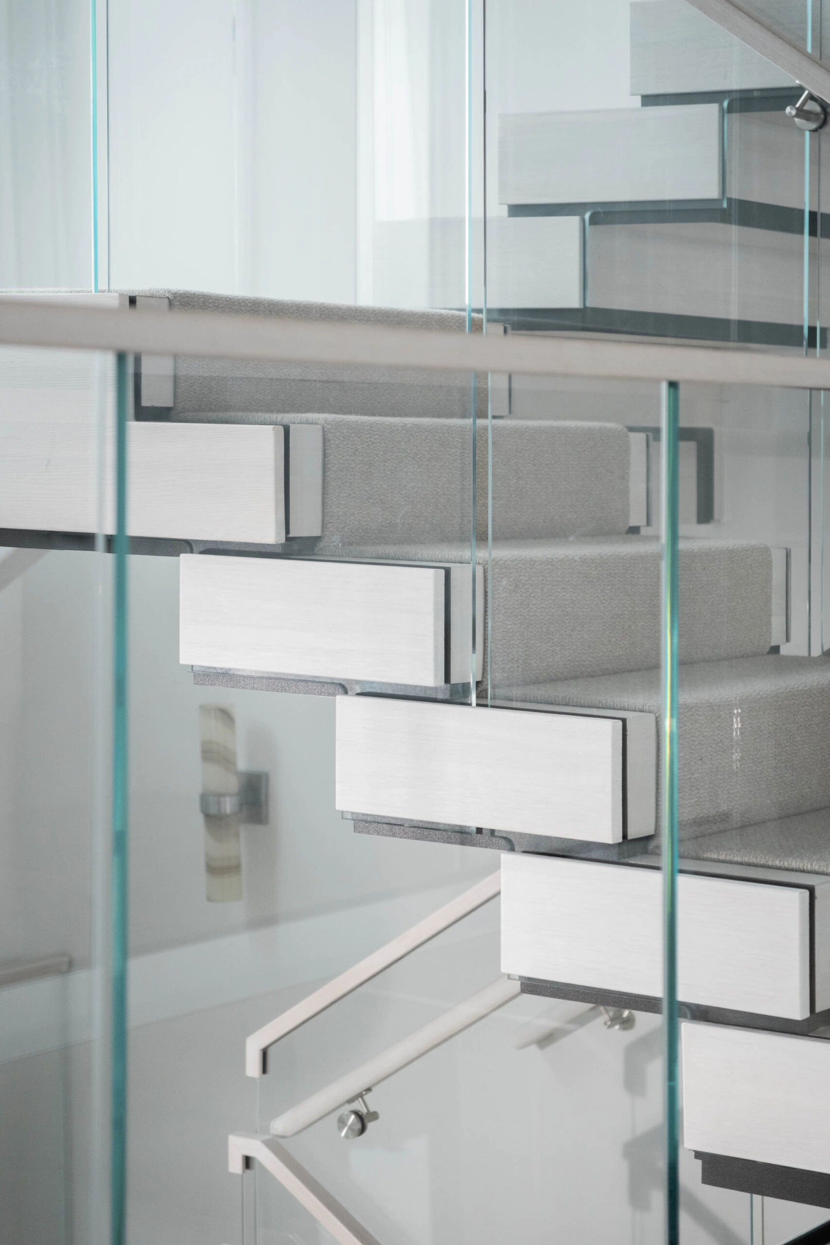 Glass panels layer in front of white FLIGHT Stack treads and a pale carpet runner