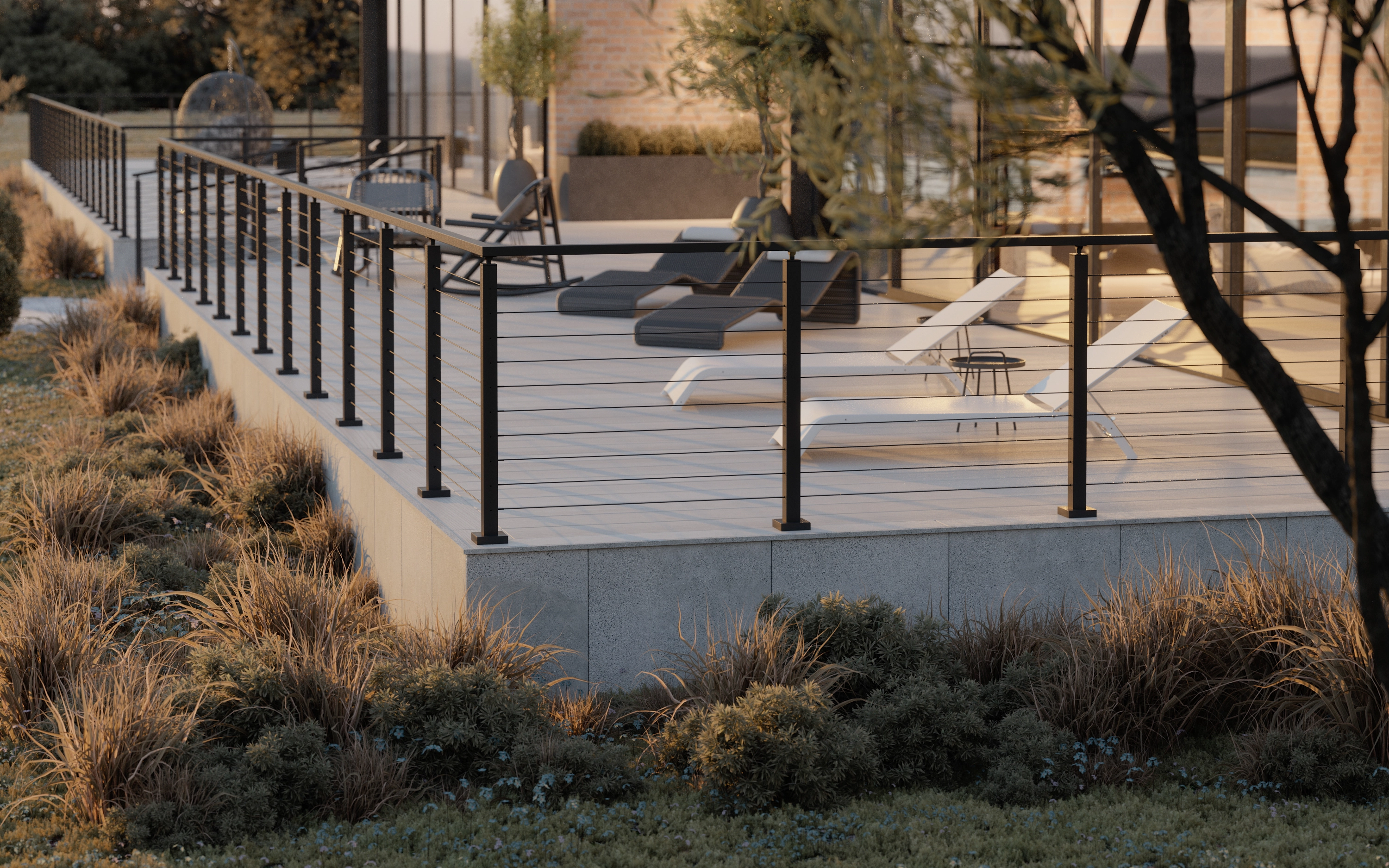 Render of a raised deck with lounge chairs, bordered by Signature Rod railing and ornamental grasses