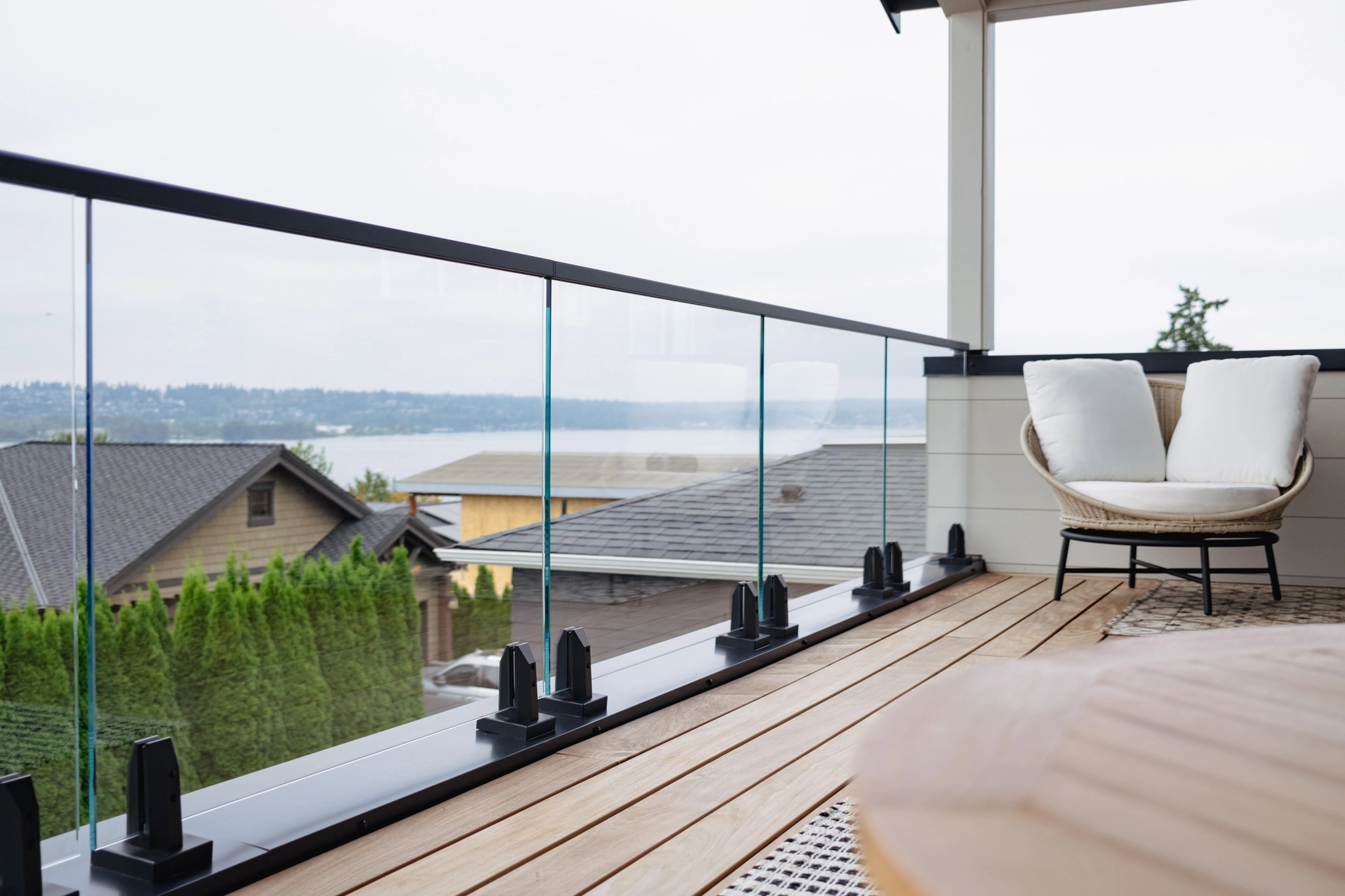Ultra-clear glass rails the same deck balcony, panels near-colourless against rooftops and water