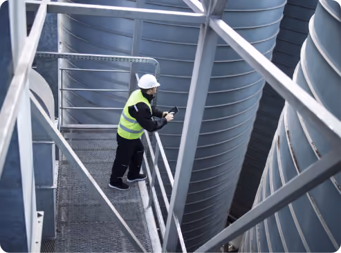 Técnico inspeccionando estructura industrial de estanques