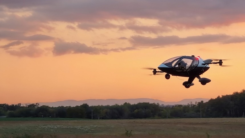 The JP1 in flight above a field at sunset