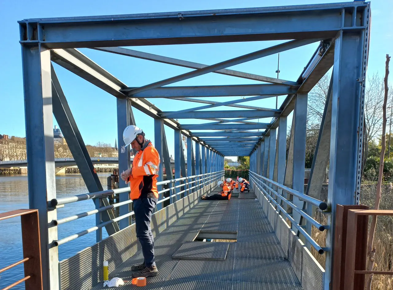 Collaborateurs en inspection sur une passerelle métallique