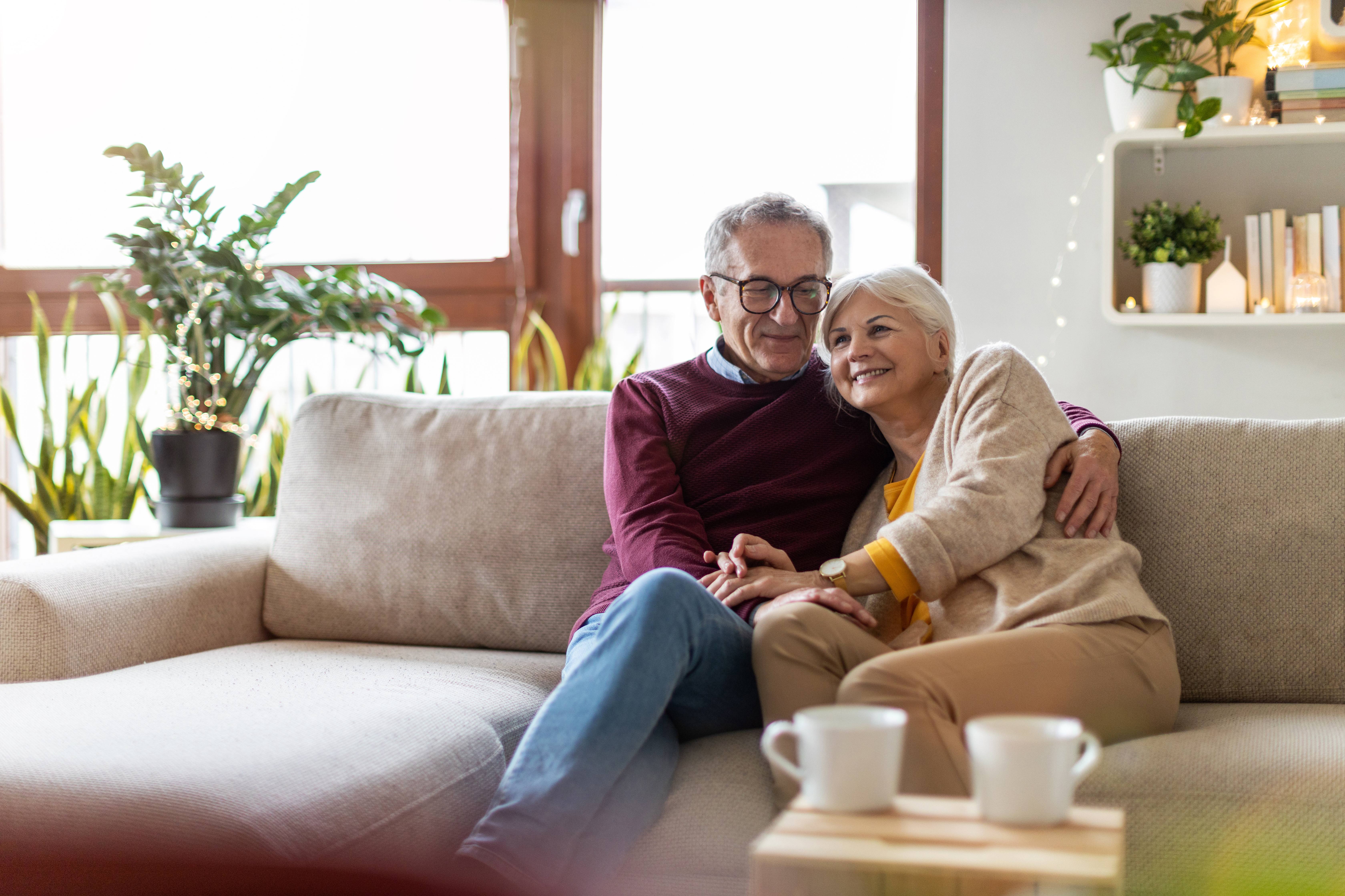 Senior man and woman sitting on couch