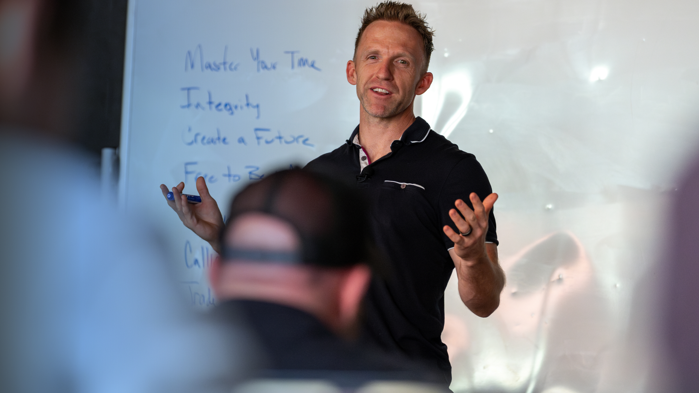 Coach explaining a sales system at a whiteboard