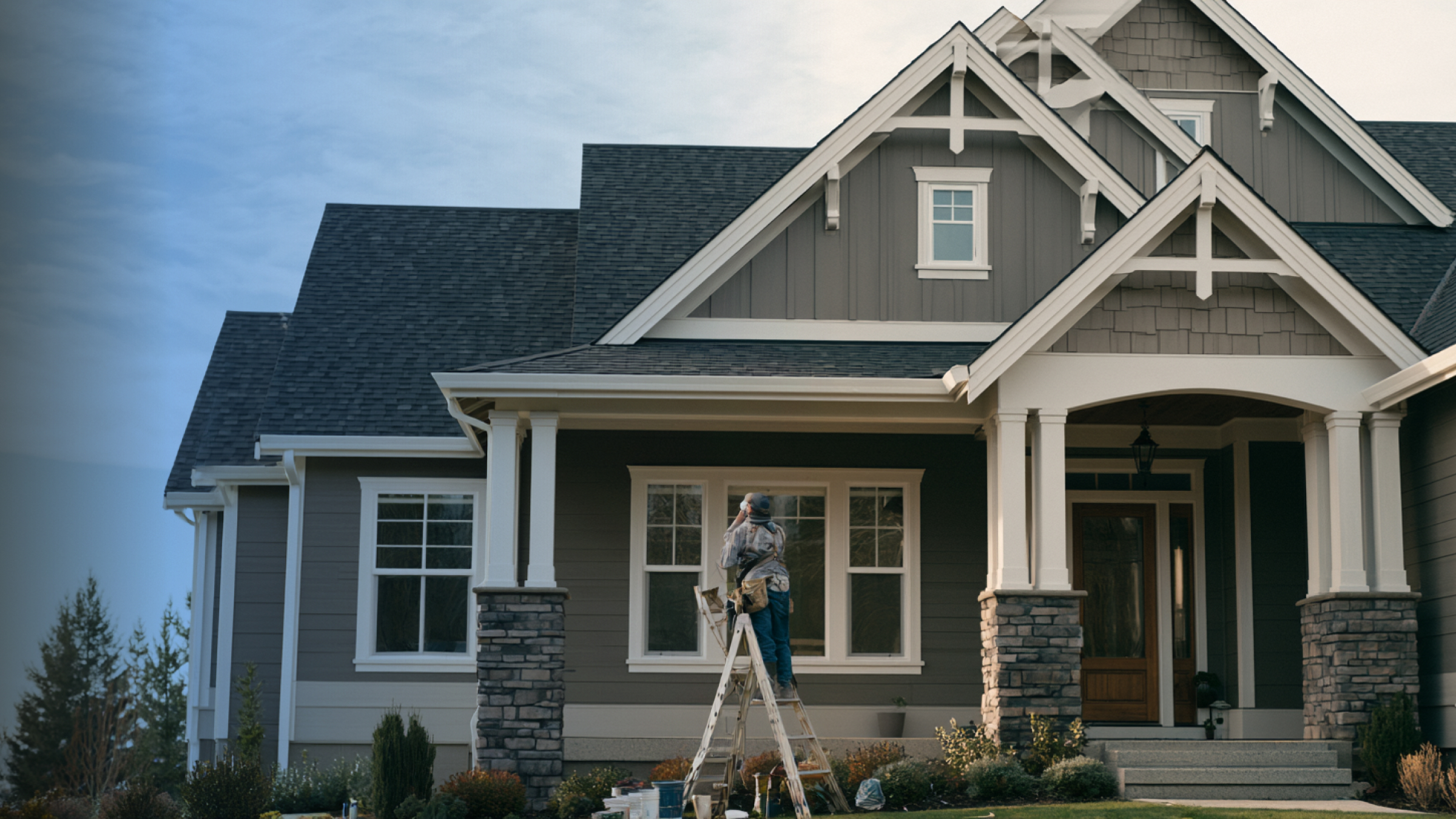 Painter working on the exterior of a craftsman home