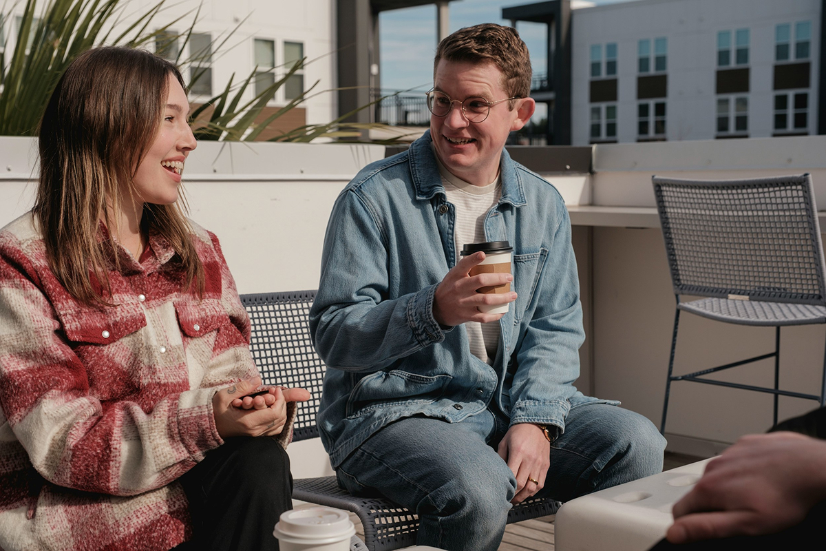 A woman and man talking to each other outside.