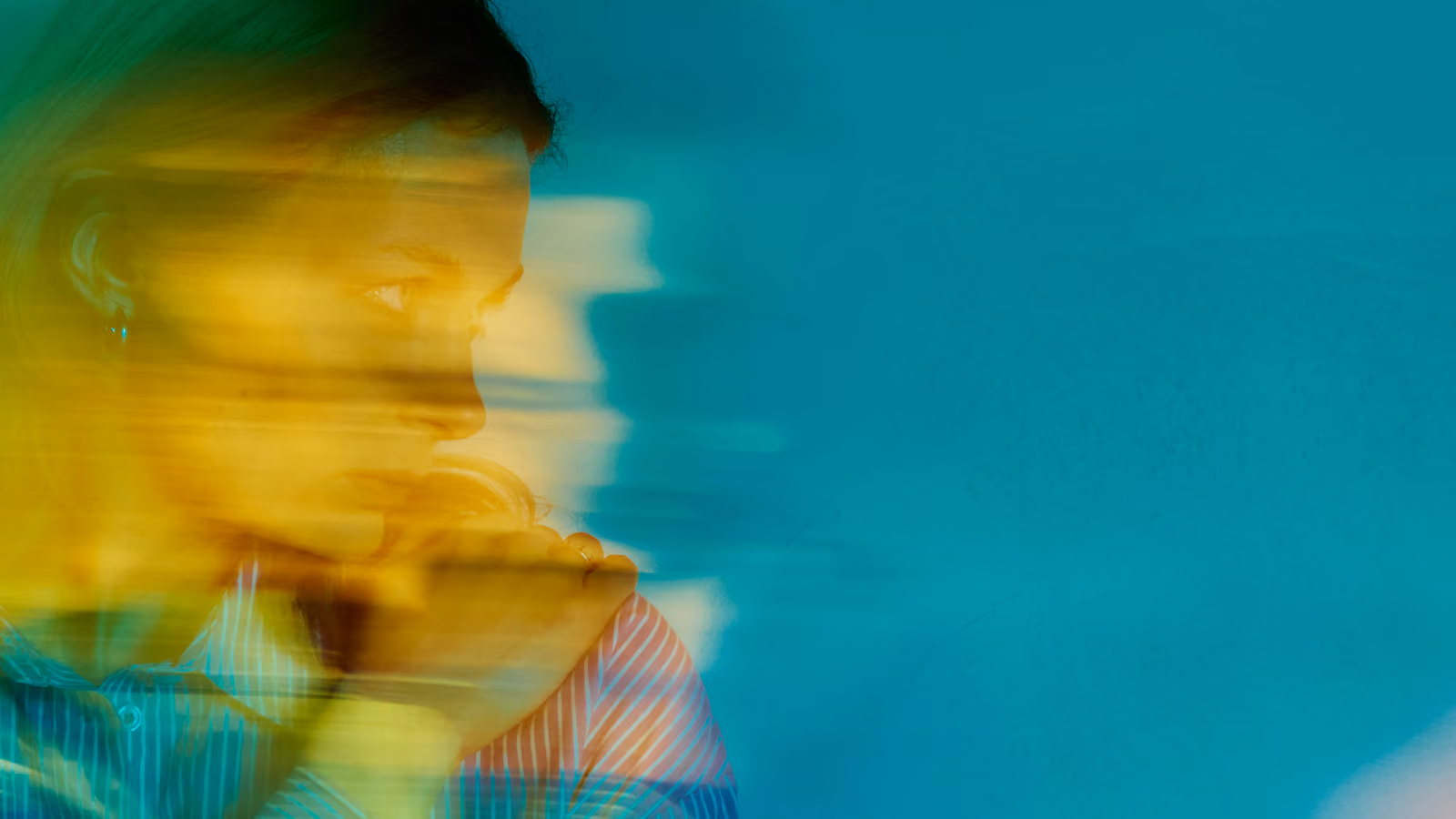 A blue and yellow image of a blurred person.