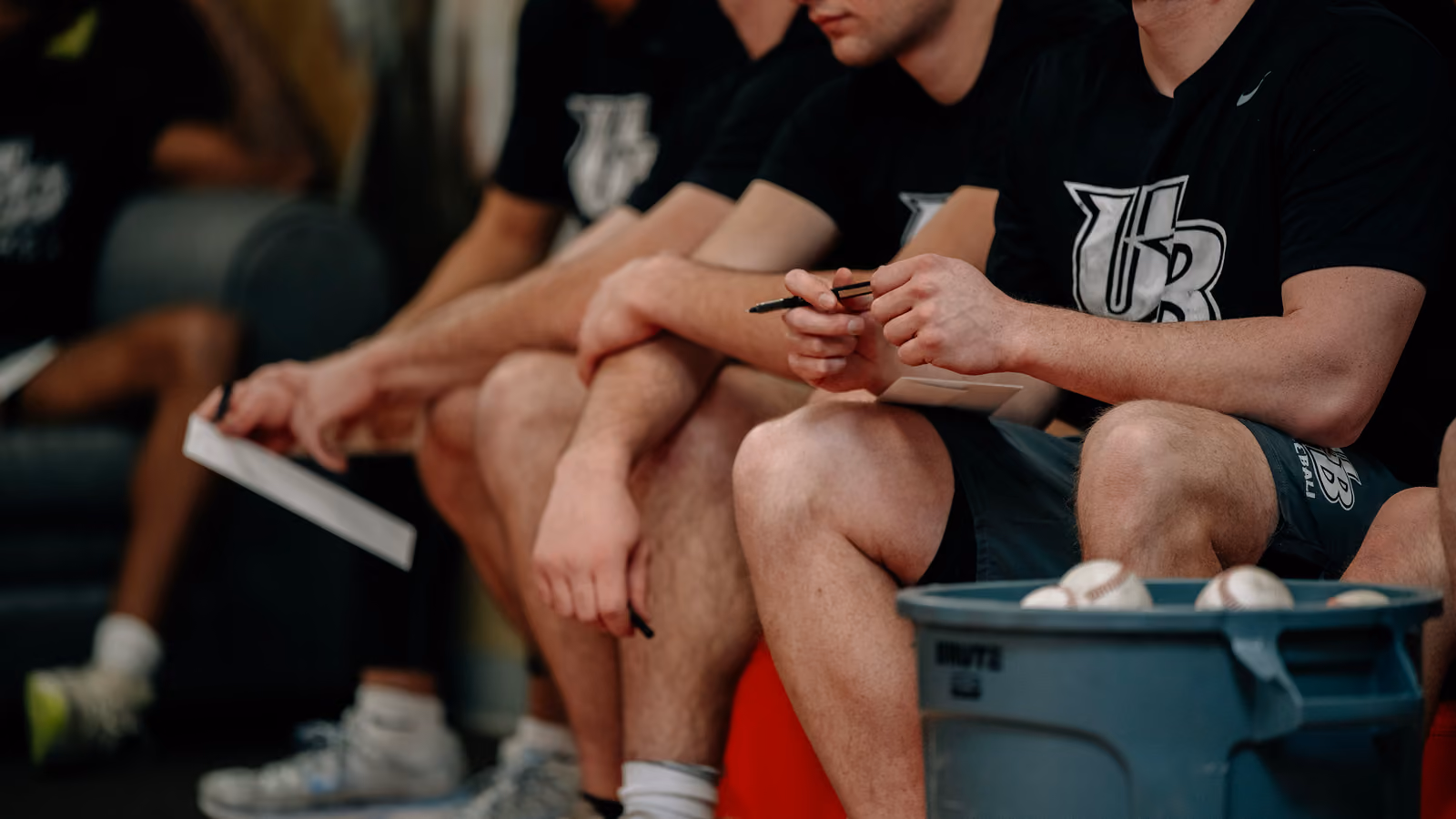 A team of baseball players sitting down in a row.