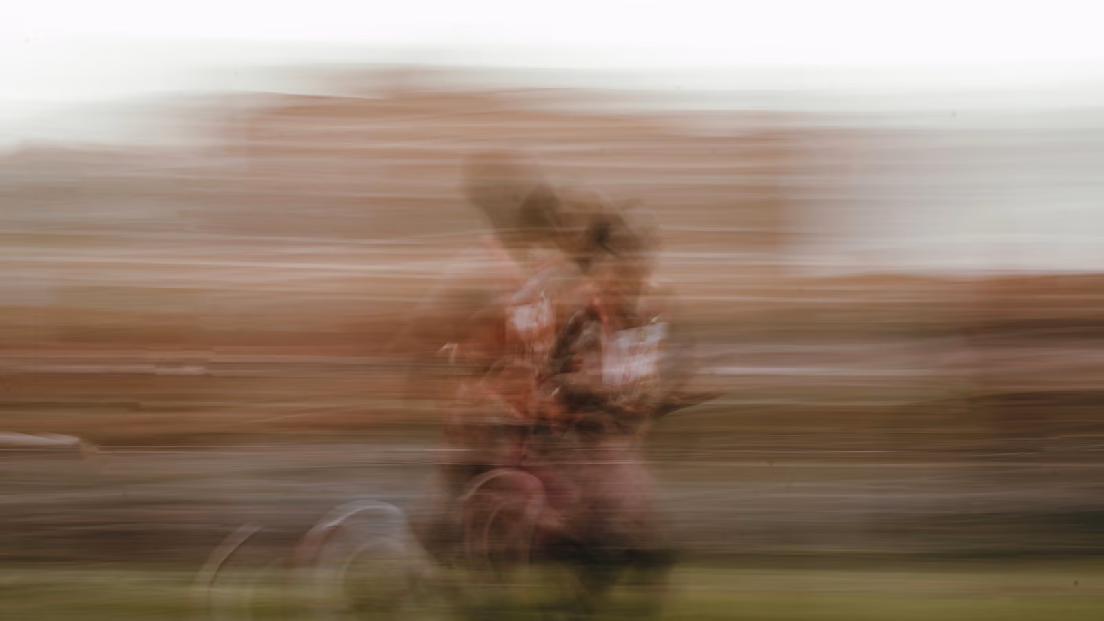 A blurred image of a runner outside.