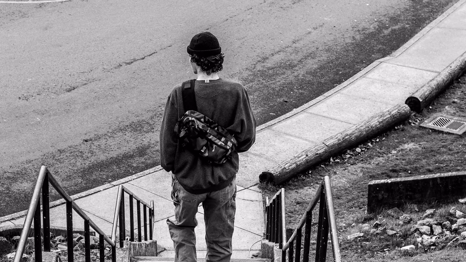A young man standing on stairs outside.