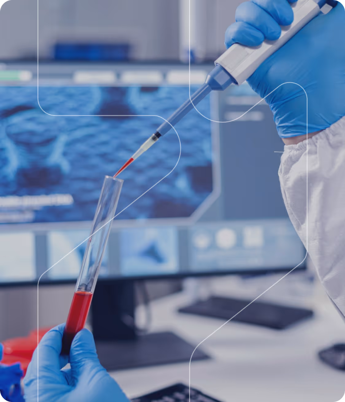 Gloved hand using pipette to transfer red liquid into a test tube in a lab with screen in background.