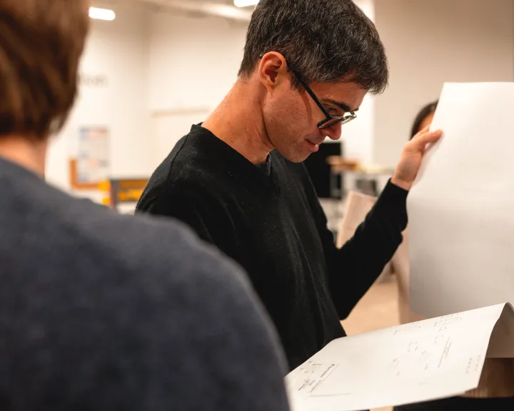 Engineer reviewing printed electrical schematics during the control panel design phase.