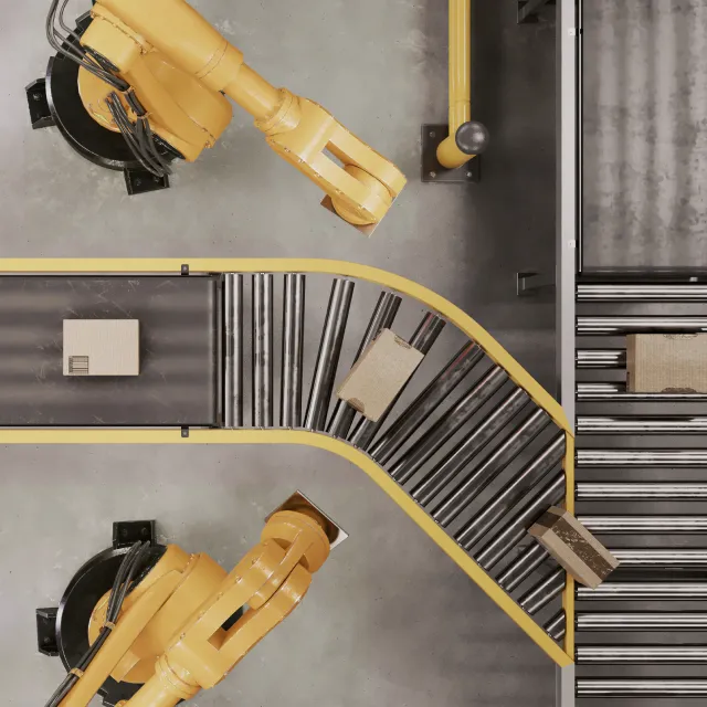 Overhead view of robotic arms and roller conveyors in a logistics automation line that relies on custom control panels.