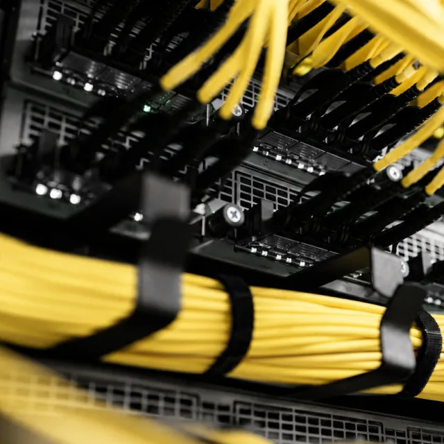 Bundled yellow network cabling in a data center server rack, an environment powered by industrial control panels.
