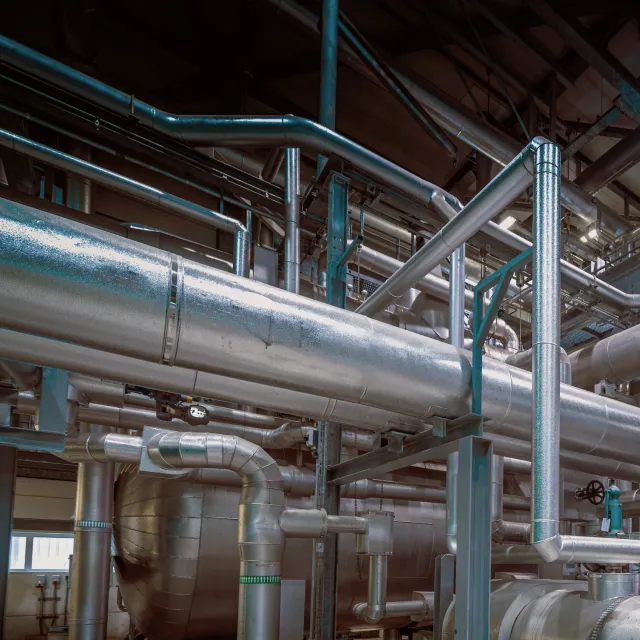 Insulated process piping in an industrial processing plant, the kind of facility Podium Automation supplies control panels to.
