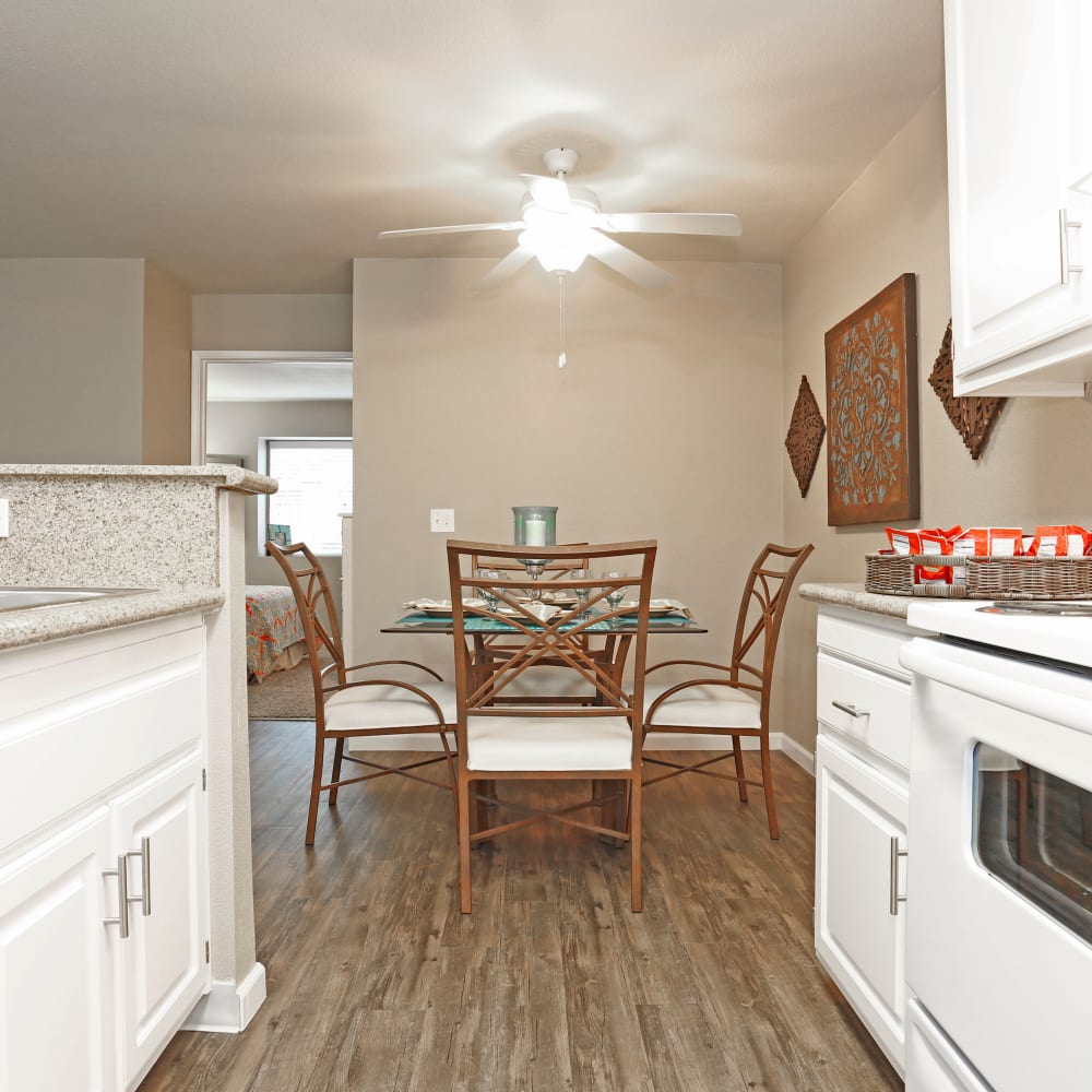 Kitchen with white cabinets and view of dining room with table and chairs