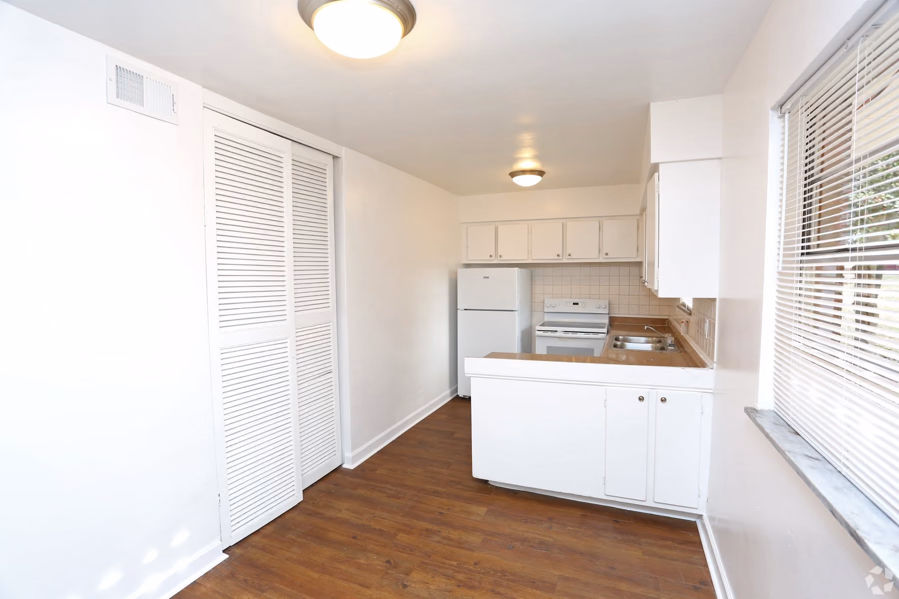 Dining area and kitchen with white appliances and white cabinets