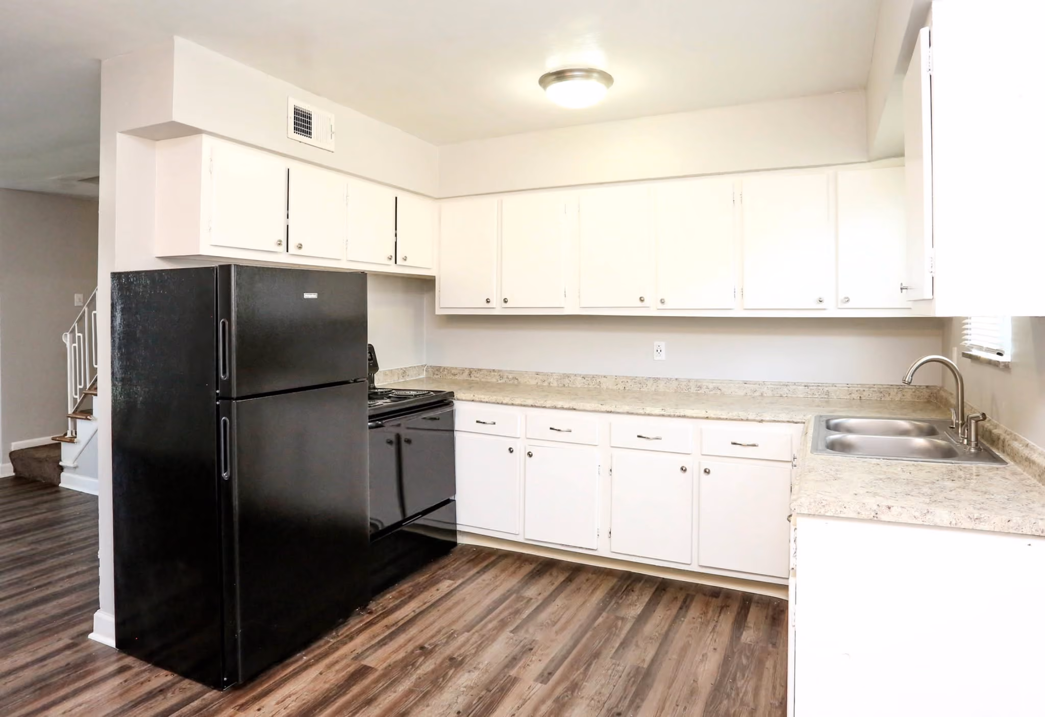 Kitchen with black appliances and white cabinets
