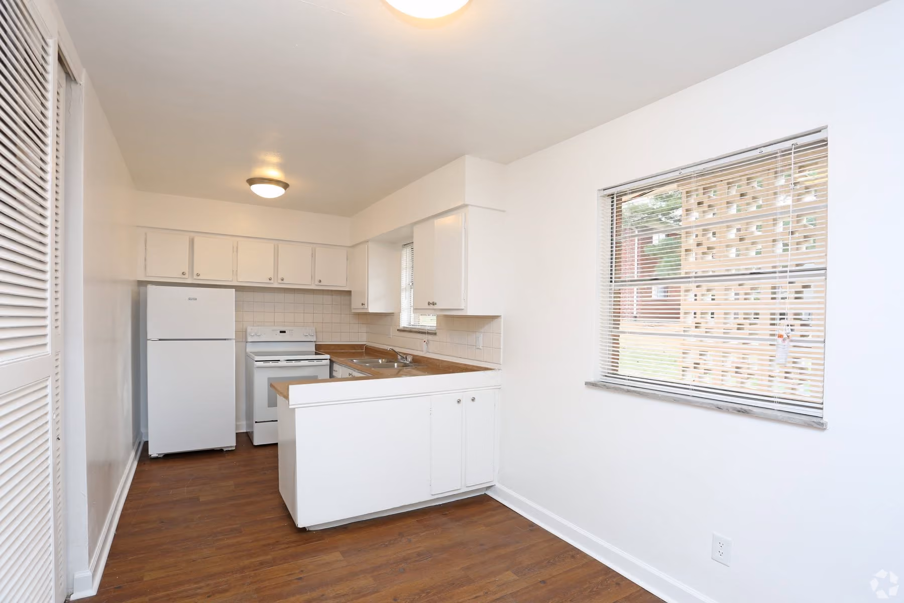 Dining area and kitchen with white appliances and white cabinets