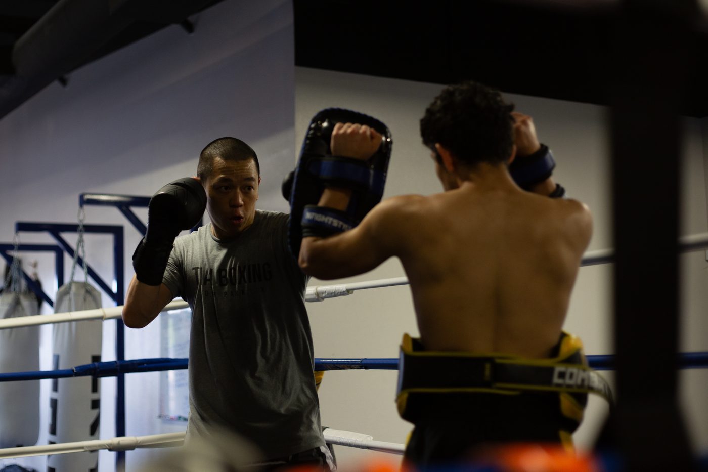 Student striking pads held by a partner in the ring during Intermediate Muay Thai class at Alliance Thai Boxing Academy