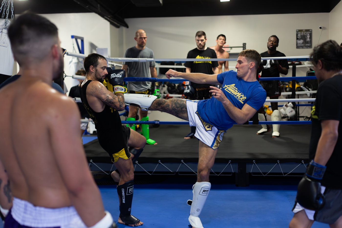 Student landing a kick on a partner's guard while the class watches during Advanced Muay Thai at Alliance Thai Boxing Academy