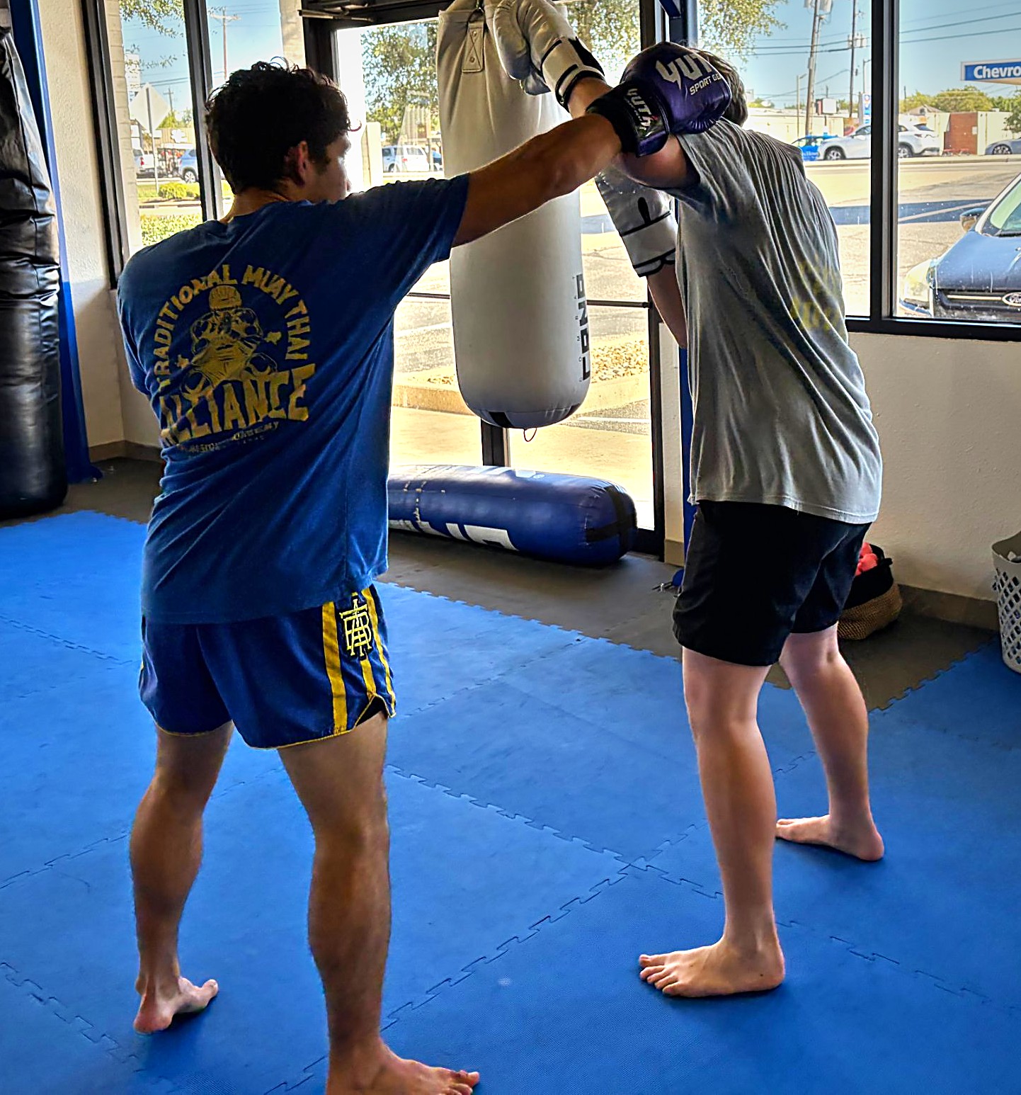 Coach working one-on-one with a student during a small group Muay Thai class in Cedar Park