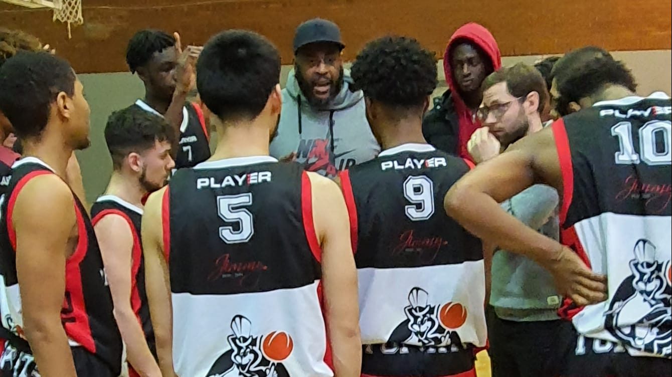 A Topcats coach talking with players during a team huddle