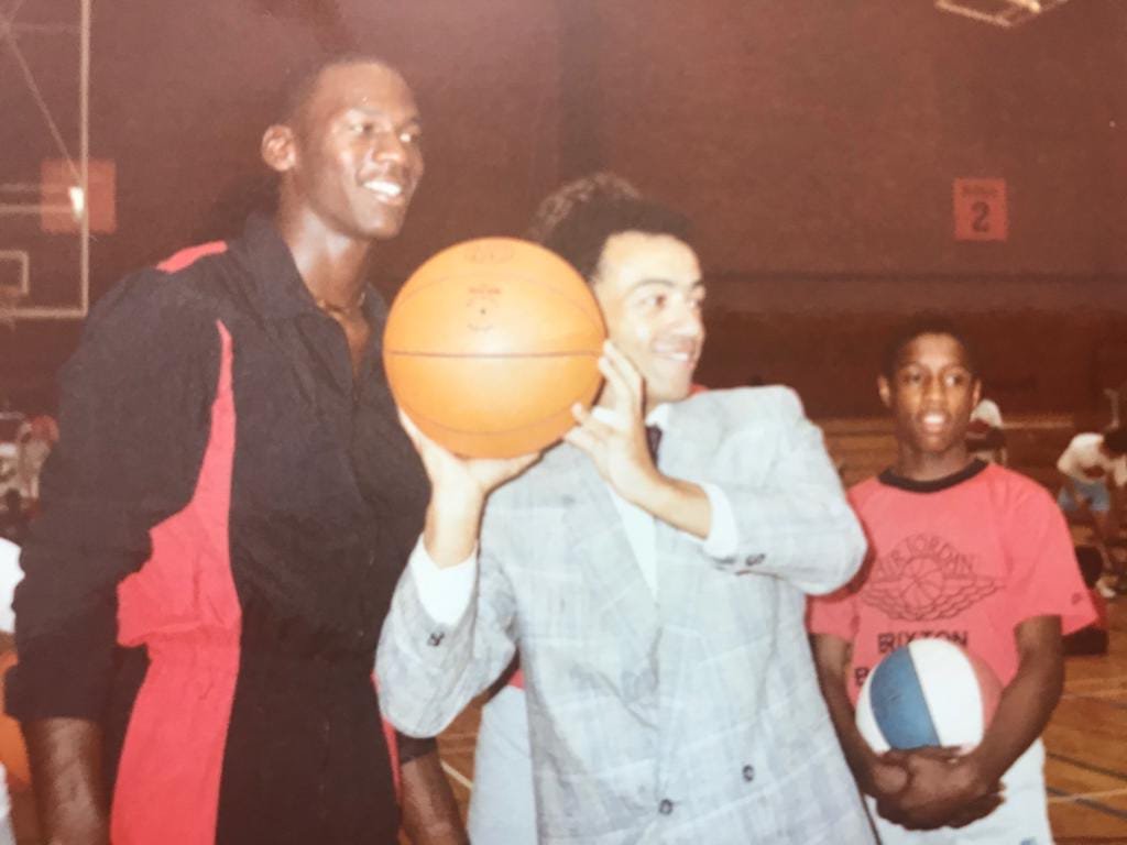 Michael Jordan holding a basketball with Jimmy Rogers at Brixton Topcats