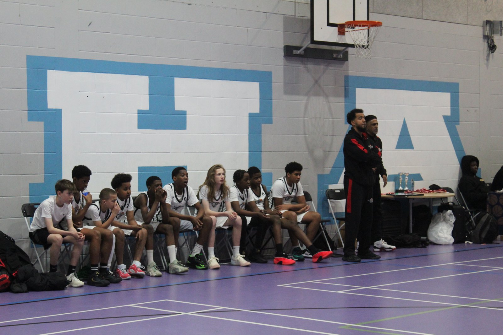 The Brixton Topcats Under-13 bench with their coach during the final