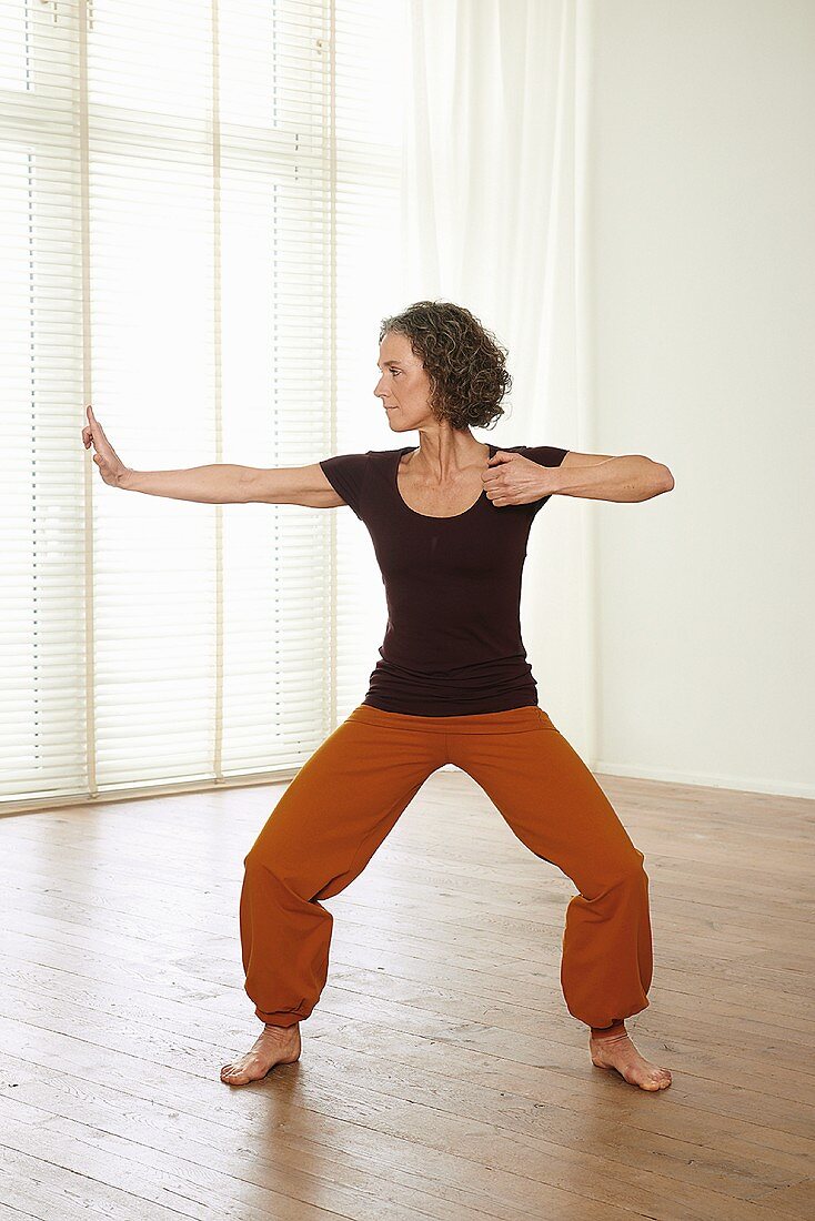 a woman performing tai chi exercise drawing the bow