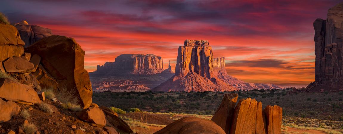 Red sunset sky over rock formations in Monument Valley