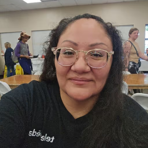Selfie of a woman with glasses wearing a Televeda shirt